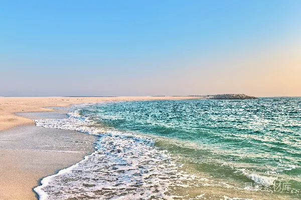 高清摄影 一片沙白的海滩，海浪涌向岸边