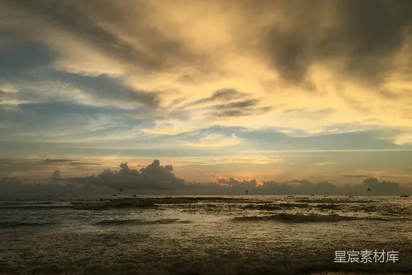 高清摄影 一天中的傍晚，天空布满了乌云，夕阳正慢慢沉入海面。