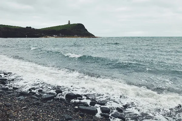 高清摄影 远处有一座灯塔的岩石海滩
