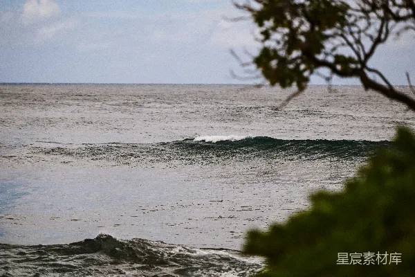 高清摄影 海天一线间，小浪在模糊的天空下拍打。