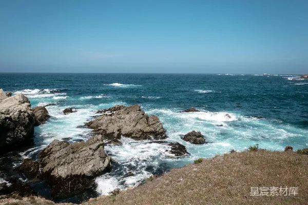 高清摄影 岩石海岸在蓝天白云下与海洋相遇。