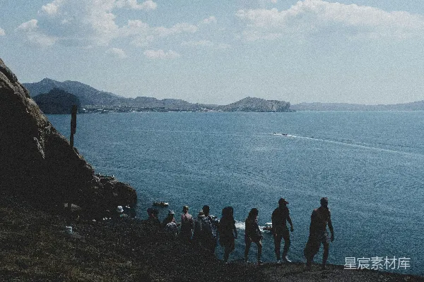 高清摄影 海边白天人们站在岩石形成的结构附近。