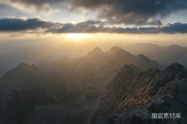 高清摄影 山峰上阳光穿透云层的缕缕光芒。