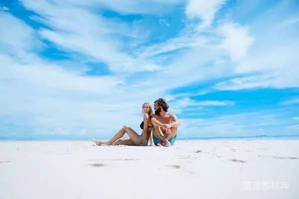 高清摄影 男性坐在一位黑色比基尼上衣女性的一侧