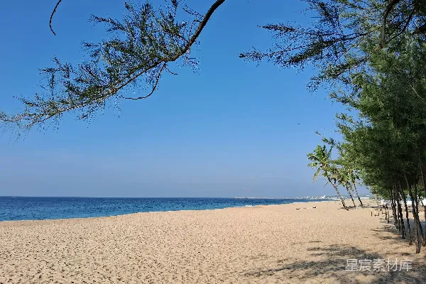高清摄影 蓝天下的海边沙滩，旁边是大海。