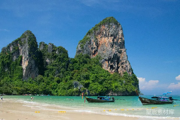 高清摄影 一个有小船和背景中大型岩形成群的海滩，Railay Beach 在背景中。