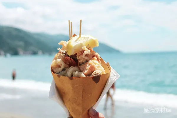 高清摄影 海滩上有人举着一个食品锥状物。