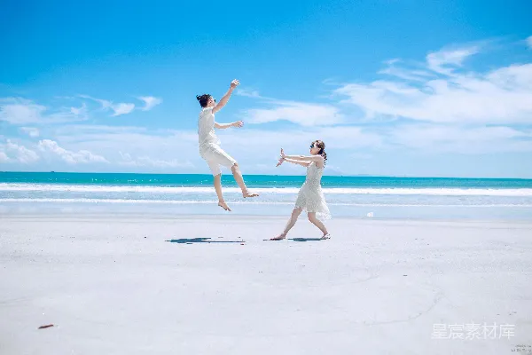 高清摄影 男人和女人在海滩白色沙地上白天玩耍