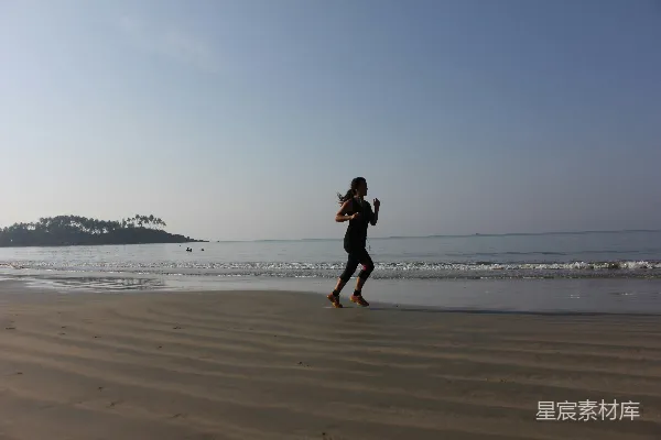 高清摄影 黑裙女子白天在海滩上跑步