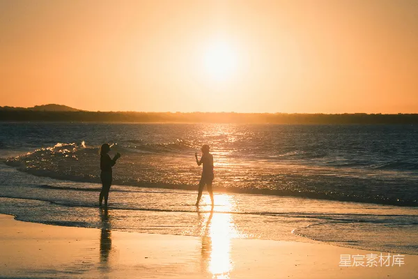 高清摄影 夕阳下两人在海滩上的轮廓