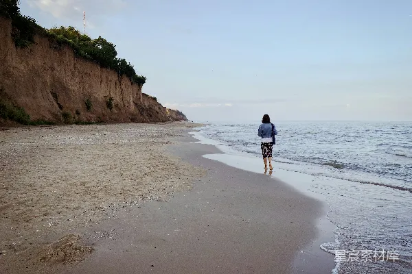 高清摄影 黑衣人在白天海滩上行走。