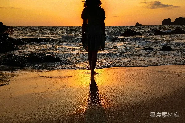 高清摄影 海边一个女人站在沙滩上。