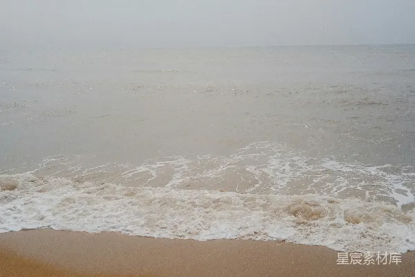 高清摄影 一片沙滩上波浪涌向岸边