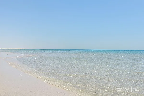 高清摄影 蓝天下的海边沙滩上铺着金色的沙子靠近大海
