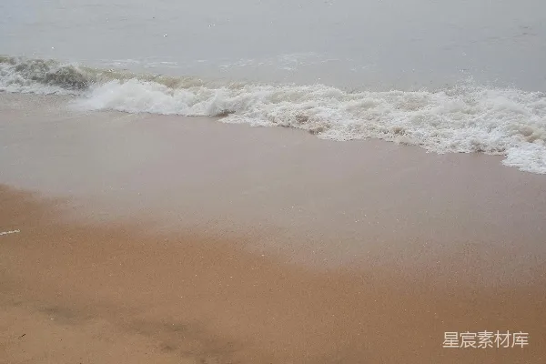 高清摄影 一片沙滩上波浪涌向岸边