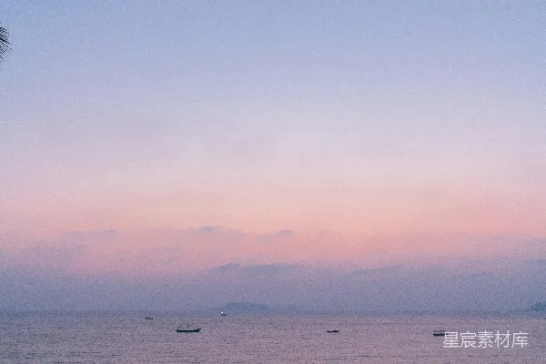 高清摄影 海滩上的人们在日落时分，海水平静。