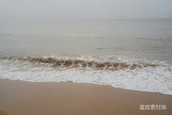 高清摄影 一片沙滩上波浪涌向岸边