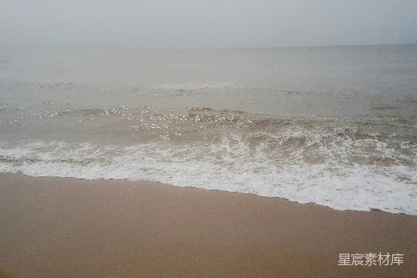 高清摄影 一片沙岸，波浪涌向岸边