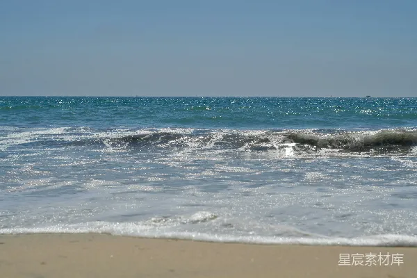 高清摄影 一片沙滩，海浪涌向岸边