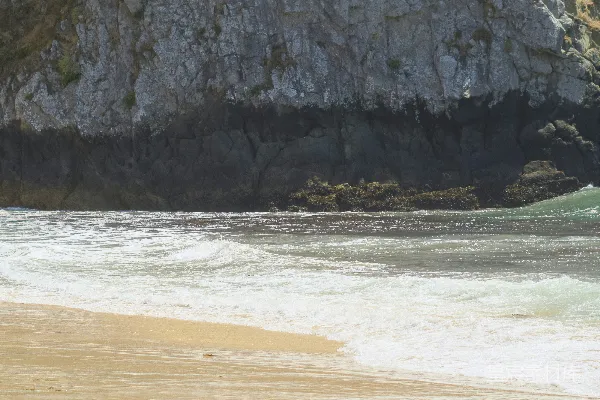 高清摄影 海滩上一个人拿着冲浪板行走。