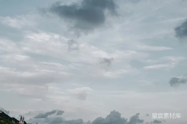 高清摄影 一个有人在沙滩上行走的海滩，天空中有几朵云。