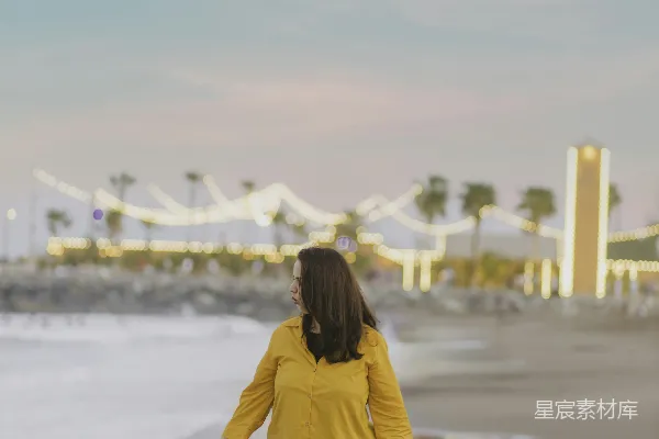 高清摄影 一个女人沿着海滩走向海边。
