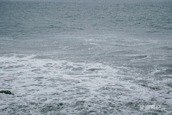 高清摄影 站在海洋中的人正在拿着冲浪板