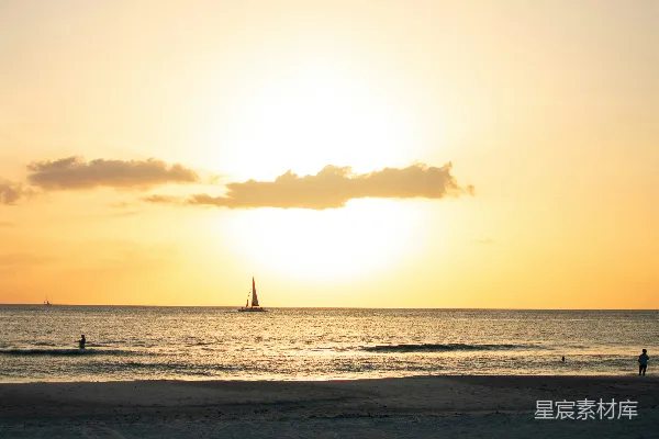 高清摄影 夕阳西下，海面上有一艘帆船在远处。