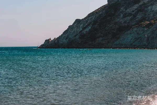 高清摄影 海边的一片沙滩旁边有一座山在背景中。