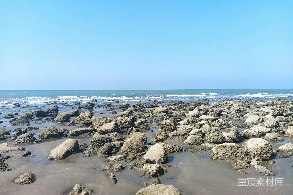 高清摄影 一片岩石海滩，水下是蓝天下的碧波