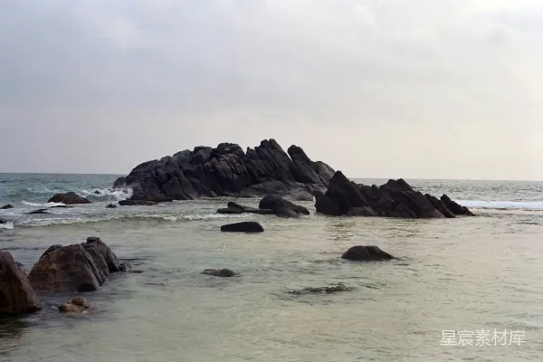 高清摄影 一块岩石嶙峋的海滩，海浪拍打着岸边
