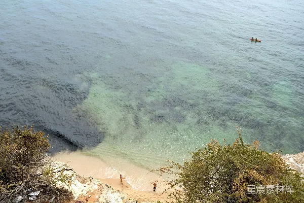 高清摄影 一群人在海滩上站着，旁边是海洋。