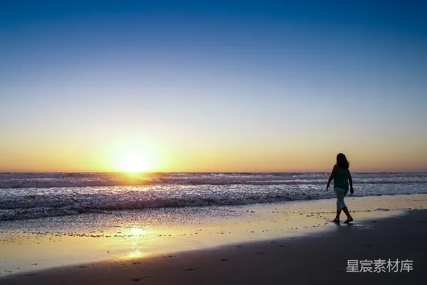 高清摄影 傍晚女子沿着海滩漫步