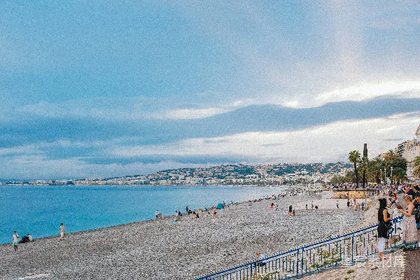 高清摄影 一群人在海边的沙滩上站立着，靠近大海。