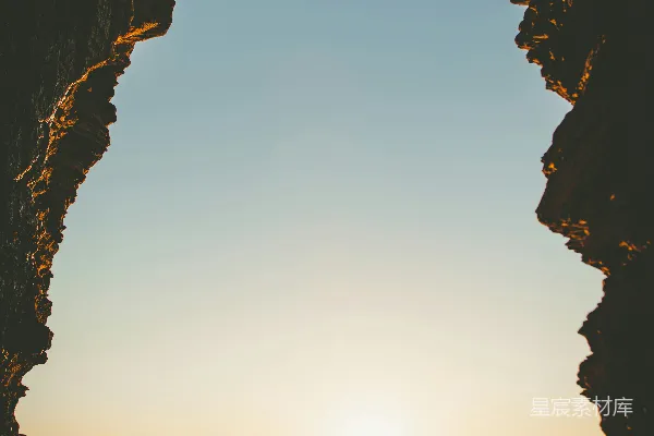 高清摄影 夕阳正从一个洞穴中洒落在大海之上。