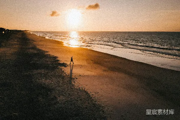 高清摄影 海滩上站立的人在日落时分