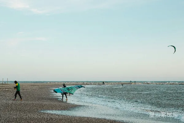 高清摄影 几个人在海滩上站立，旁边是大海。
