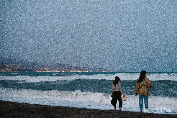 高清摄影 几位妇女沿着海滩走，在海边附近