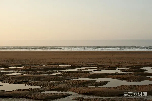 高清摄影 一片沙子铺就的海滩，海浪拍打著岸边