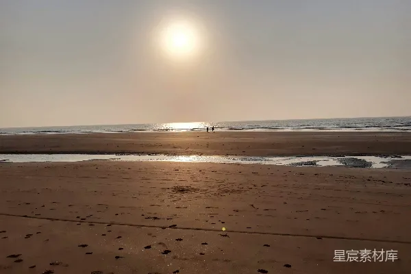 高清摄影 海边日落时海浪拍打在沙滩上