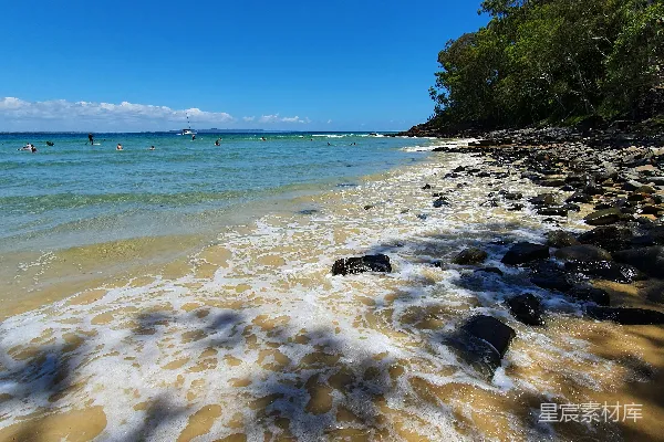 高清摄影 一片沙子覆盖的海滩，海浪涌向岸边。