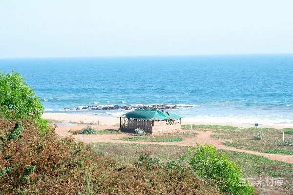 高清摄影 一个 gazebo 坐落在沙滩上，紧挨着海边的沙丘之中。