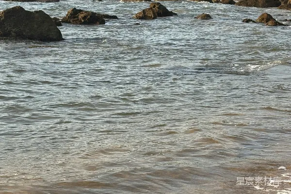 高清摄影 一片沙子铺成的海滩，海浪涌向岸边。