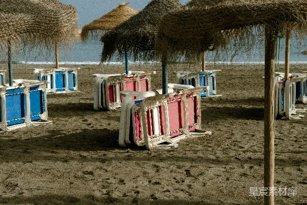 高清摄影 空旷的海滩上设有草编阳伞和折叠椅