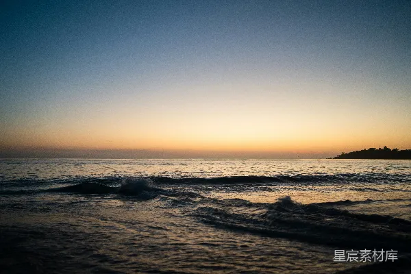 高清摄影 夕阳西下，海面上有一座小岛隐约可见。