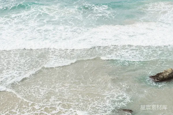 高清摄影 海滩上站立着一个拿着冲浪板的人