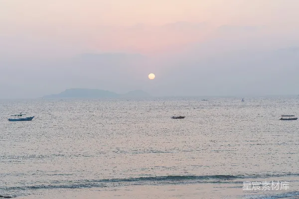 高清摄影 海边黄昏时分的烟雾弥漫与海滩上的人们。