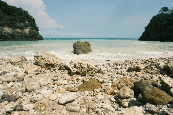 高清摄影 一片中间有大岩石的崎岖海滩