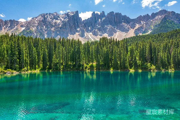 高清摄影 近水边有绿草地，山峦环绕在附近。