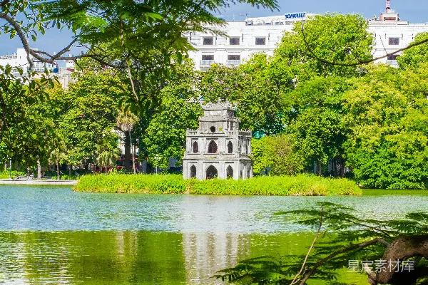 高清摄影 环绕着树木的一片湖泊，在背景中有一座建筑。